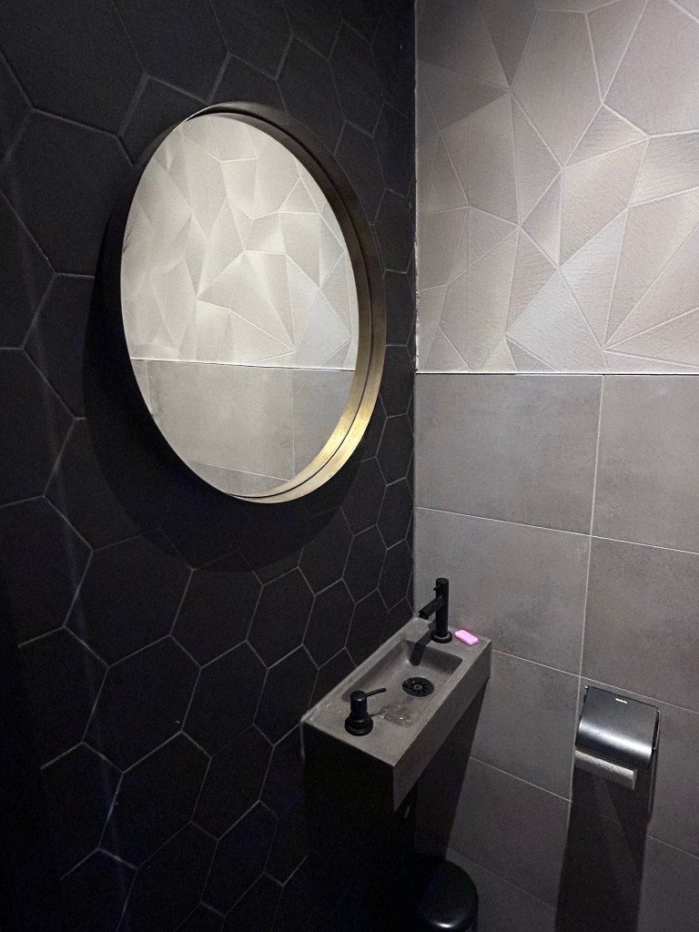 WC renovatie met zwarte zeshoek tegels en spiegel Gouda