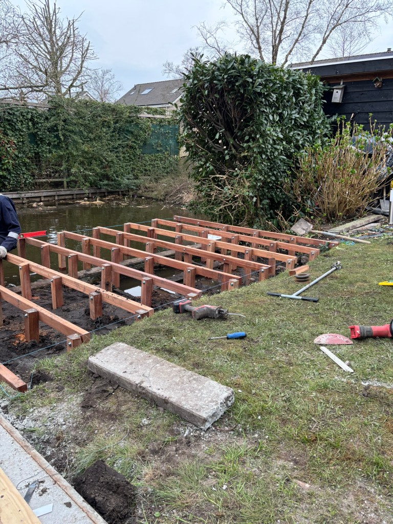 Houten palen geplaatst als basis voor steigerconstructie