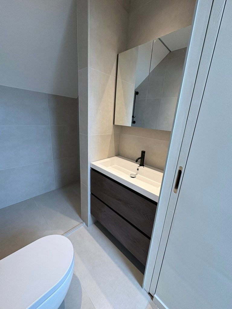 Nieuwe badkamer met spiegel, wc, badkamermeubel en douche